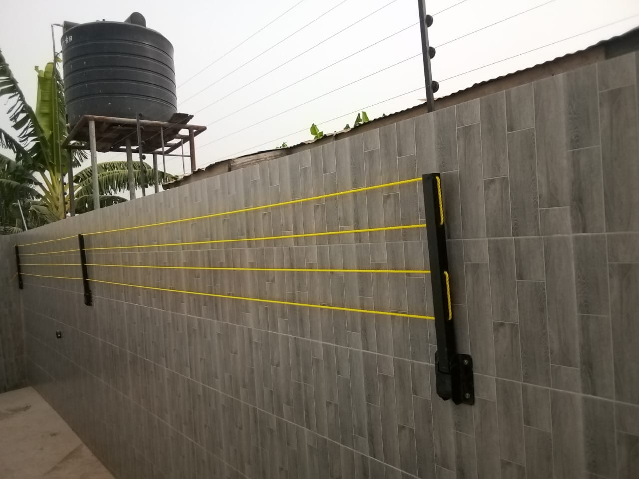 Foldable drying line with amber lines fixed to a tiled compound wall at a Ghanaian home