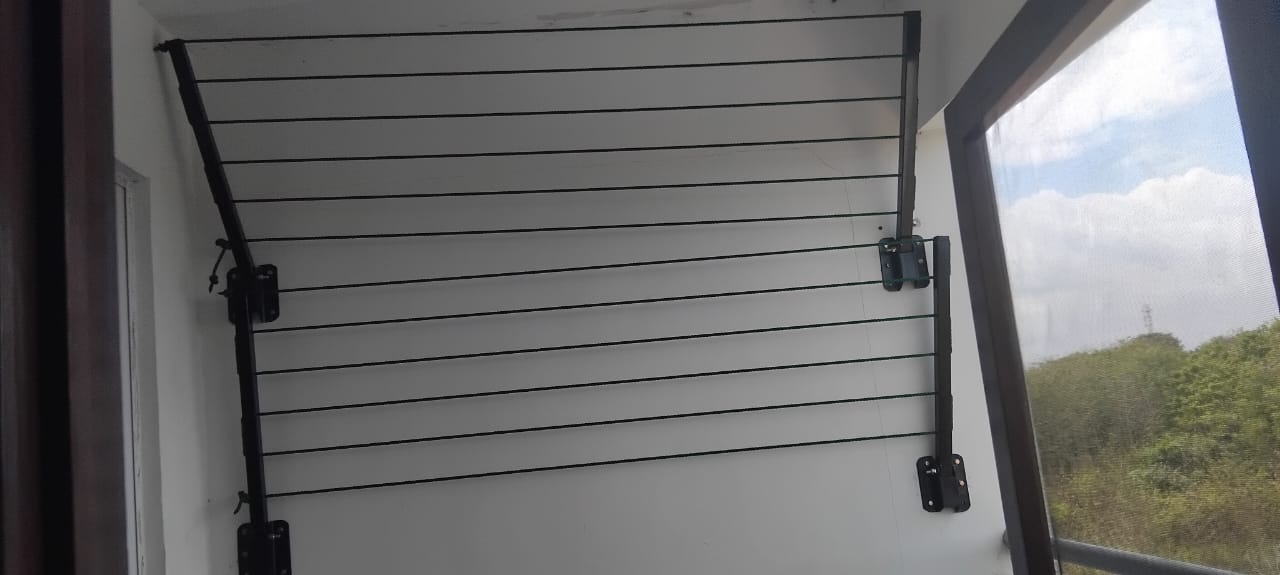 Foldable drying line fitted inside a covered utility area beside a doorway