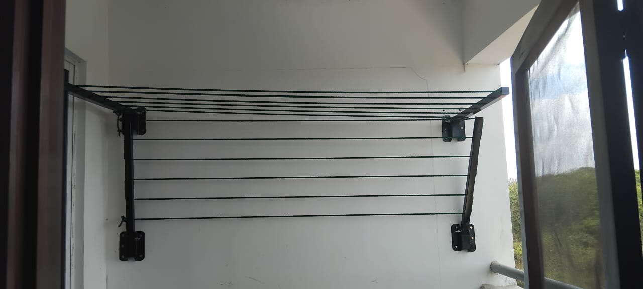 Foldable drying line mounted inside a laundry room, lines spanning the wall
