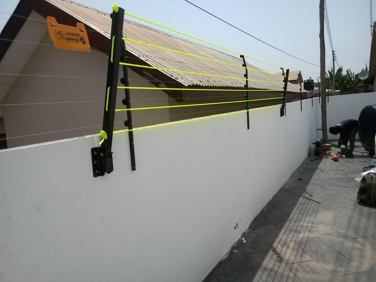 Foldable drying line mounted on a white compound wall, lines running to a second wall post
